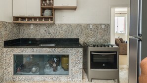 A kitchen with a built-in stove, oven, and a glass-fronted storage cabinet. - 3-bedroom Apt and Ocean View Edi0302 (Salvador)