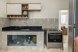 Une cuisine équipée d’une cuisinière, d’un four et d’un meuble de rangement avec une porte en verre.