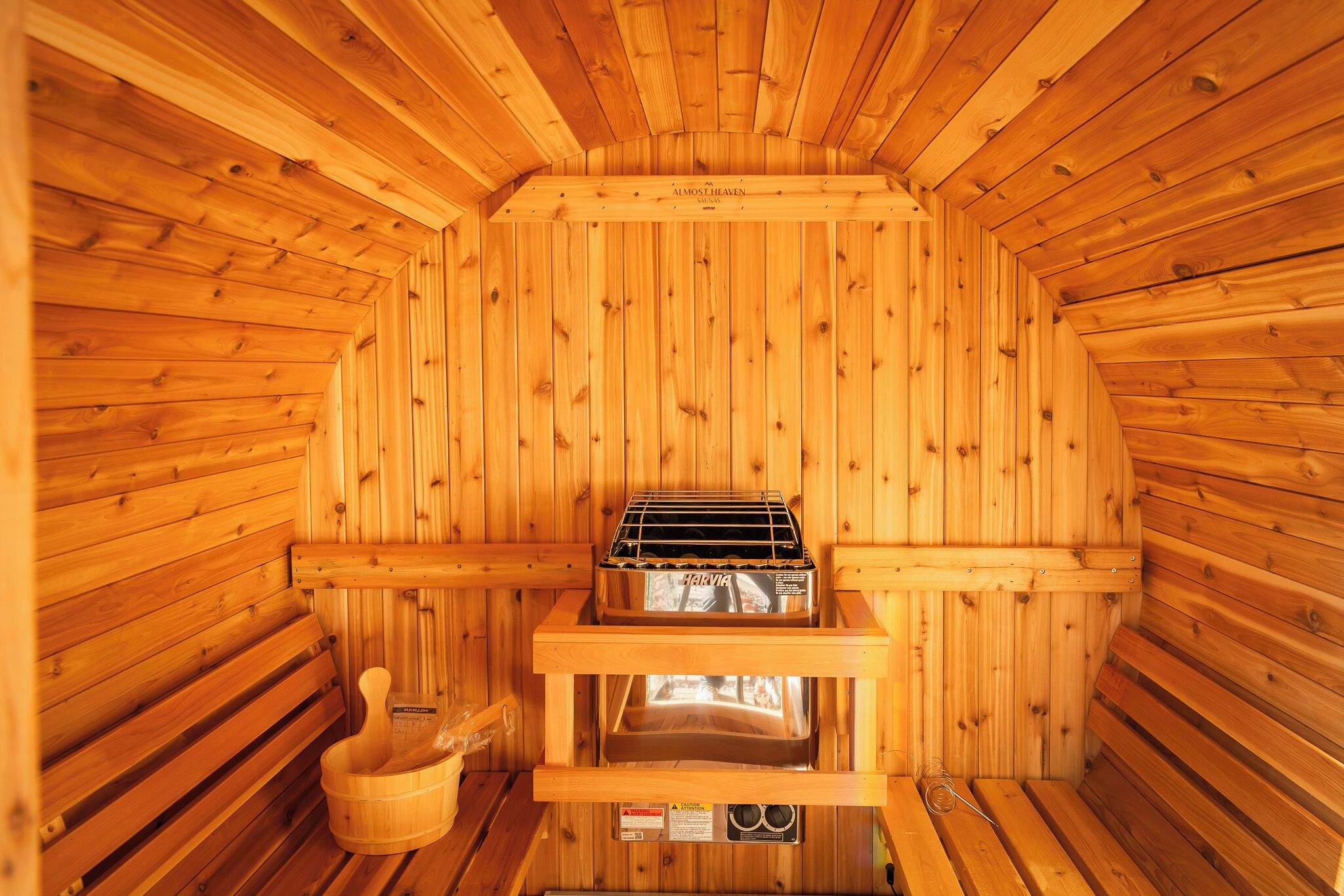 Un sauna avec des murs en bois et un banc.