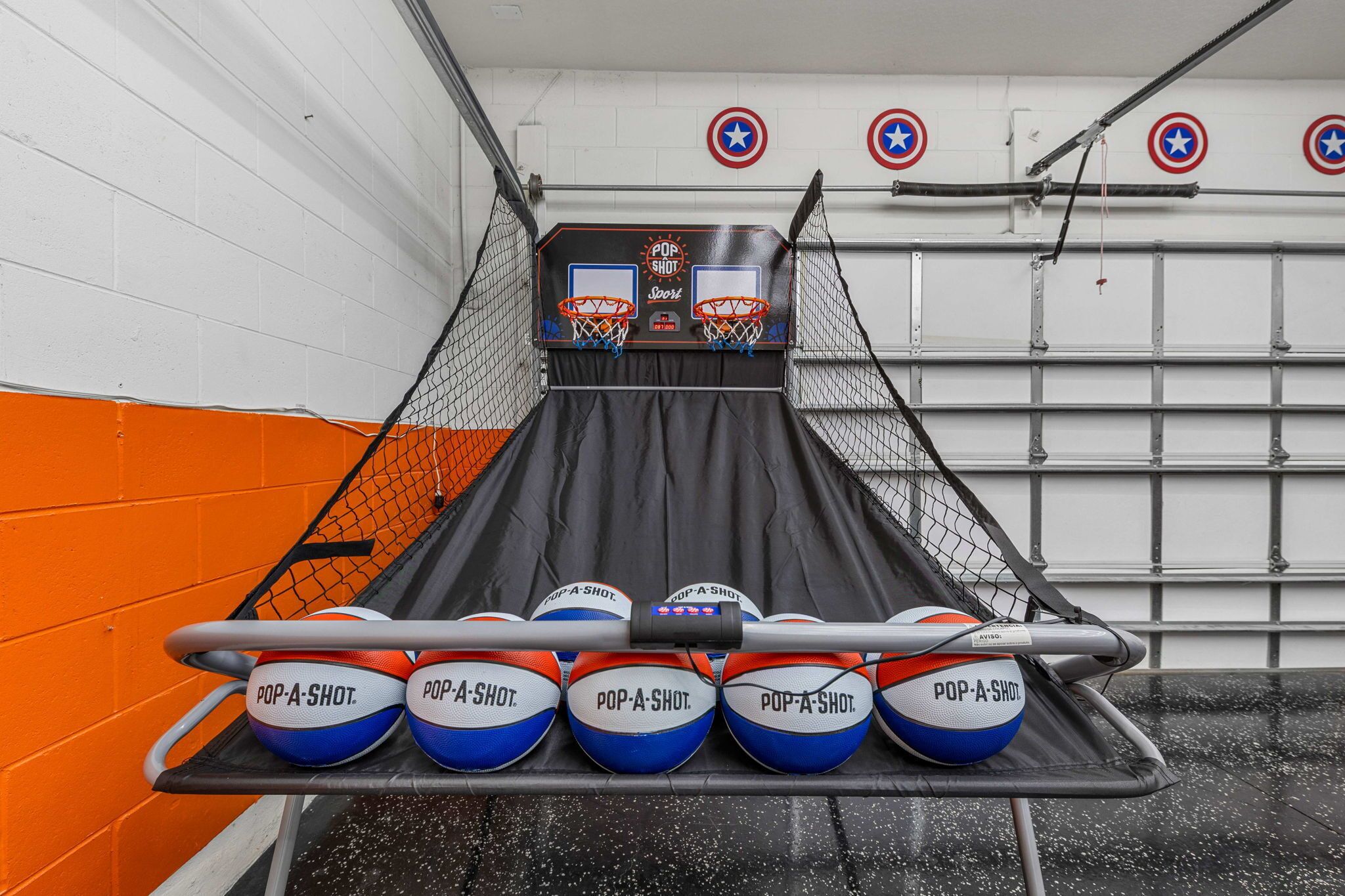 Een basketbal-arcade met meerdere basketballen voorzien van de tekst 'POP-A-SHOT' en een 'POP SHOT'-bord boven de korven.