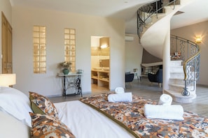 Ein Hotelzimmer mit Bett, Schreibtisch, Stuhl, Treppe und Badezimmer.