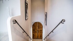 A staircase with a wooden door at the top, flanked by two black handrails and framed pictures on the walls. - L'Angélus Mas in Provence for 14 people • Heated swimming pool - Families & groups (Noves)