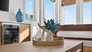 A kitchen with white cabinetry, a wooden countertop, a blue vase, and a decorative plant. - Fall Availability | Steps to Beach | 7 bdrm home (Holden Beach)