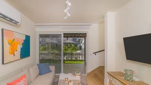 Un salon moderne avec un canapé, une table basse et un téléviseur fixé au mur.