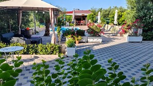 En udendørs patio med pool, siddepladser og krukkeplanter.