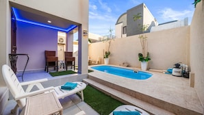 A modern outdoor pool area with lounge chairs, a hot tub, and a small garden. - Cuquisastraat 30A (Oranjestad)