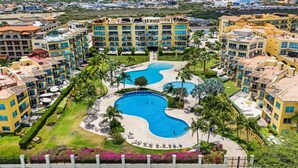 A hotel with multiple buildings, a central swimming pool, and surrounding greenery. - Oceania #365 J.e. Irausquin Blvd 238 (Oranjestad)