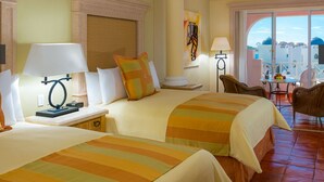 A hotel room with two beds, a sitting area with a chair, a table, and a balcony with a view. - HALF PRICE Fixed Week in Cabo San Lucas (Cabo San Lucas)