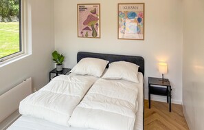 A bedroom with a bed, two nightstands, a potted plant, and two framed posters on the wall. - 4 bedroom lovely home in Knebel (Knebel)
