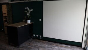 A room with a wooden desk, a whiteboard, and a potted plant. - Jung'Love room - Spa & Private Cinema (Saint-Cyprien)