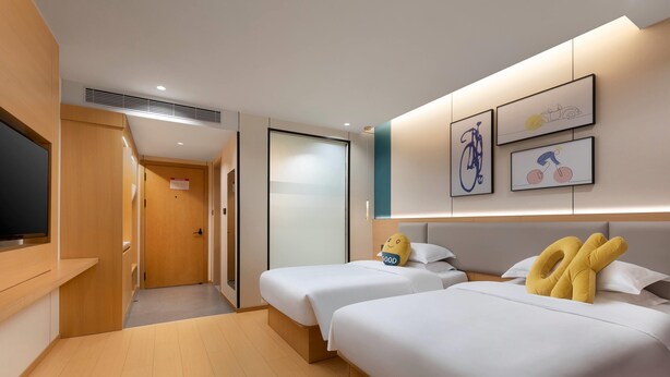 A hotel room with two beds, a TV, and artwork on the wall. - Baymont Kunming Economic Development Zone (Kunming)