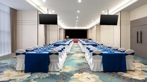 A conference room with rows of tables, blue tablecloths, white chairs, and a floral carpet. - Baymont Kunming Economic Development Zone (Kunming)