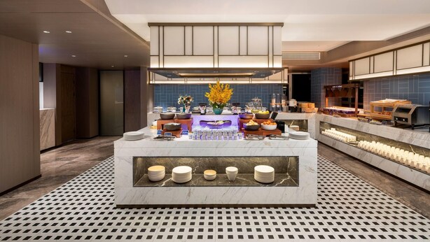 A modern hotel lobby with a central reception desk, marble flooring, and a patterned floor mat. - Days Inn By Wyndham Zhengzhou Xinzheng Airport (Zhengzhou)