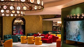 A lobby with a checkered wall, a large screen, and various seating arrangements. - Tryp By Wyndham Chongqing Downtown (Chongqing)