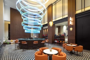 A modern lobby with a central circular seating area, a spiral light fixture, and a reception desk. - Wyndham Garden Changsha Economic Development Zone (Changsha)