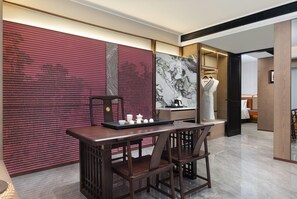 A modern interior with a dining area featuring a wooden table and chairs, a decorative wall with abstract patterns, and a large framed artwork. - Wyndham Garden Changsha Economic Development Zone (Changsha)