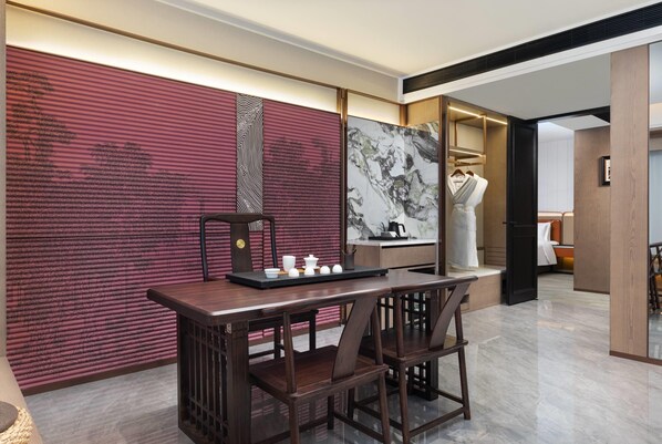 A modern interior with a dining area featuring a wooden table and chairs, a decorative wall with abstract patterns, and a large framed artwork. - Wyndham Garden Changsha Economic Development Zone (Changsha)