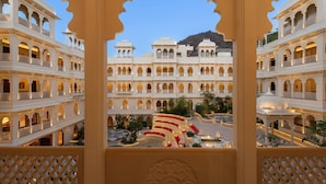 Un hotel de varios pisos con balcones, un patio interior y arquitectura tradicional.