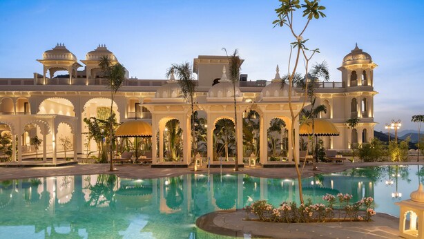 Una piscina rodeada de arquitectura tradicional, con paseos en arco y estructuras abovedadas.