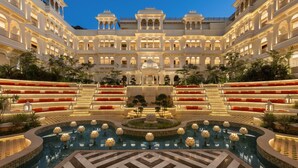 A grand hotel with a central pool surrounded by tiered seating and a fountain. - Wyndham Garden Udaipur Bhuwana (Udaipur)