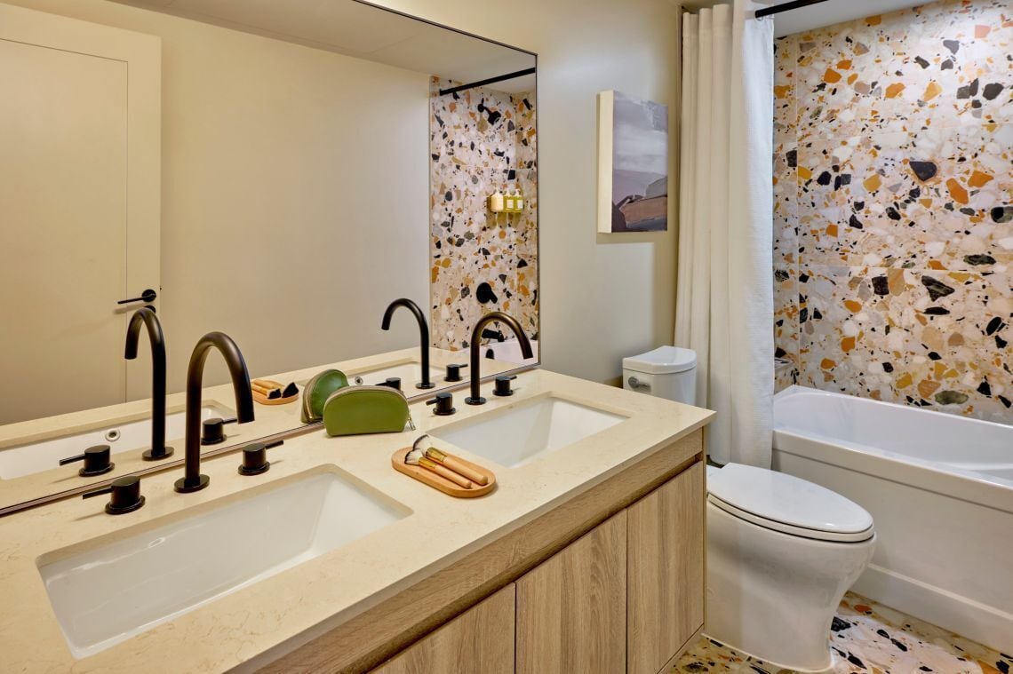 Une salle de bain avec deux lavabos, des toilettes et une baignoire.