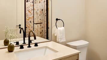 A bathroom with a sink, mirror, and toilet.
