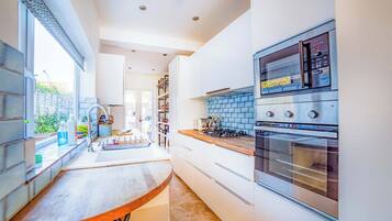 A modern kitchen with a built-in oven, a microwave, and a gas stove.