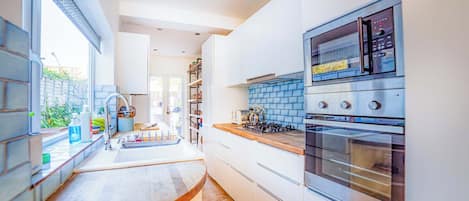 A modern kitchen with a built-in oven, a microwave, and a gas stove.