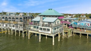A waterfront property with multiple wooden structures, including a prominent building labeled "Harbour Master Suites." - Corrigan`s Reef at Harbour Master Suites (Cedar Key)