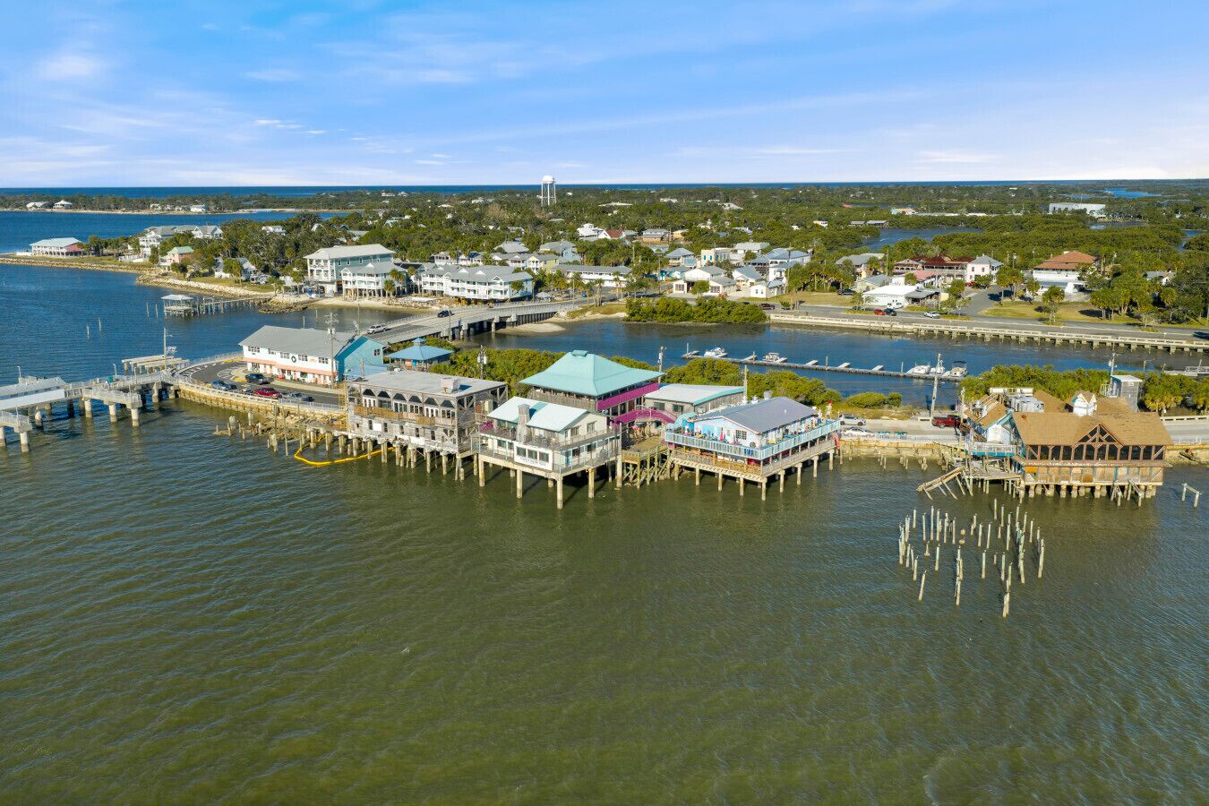 An aerial view of a waterfront property with multiple buildings, docks, and a marina.