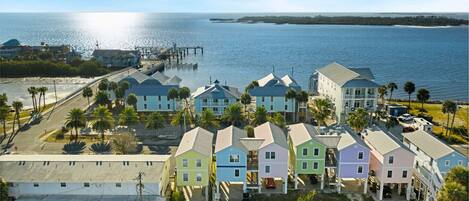 A coastal residential area with colorful houses, a pier, and a view of the ocean.