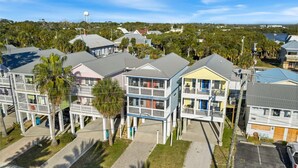 A residential area with multi-story houses, including a two-story house with a balcony and a three-story house with a blue facade. - Lucky Catch on 1 Street (Cedar Key)