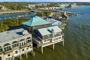 Een pand aan het water met meerdere gebouwen, waaronder een opvallend gebouw met een blauw dak en een bord waarop staat: "Harbor Master Suites".