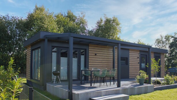 A modern house with a covered patio, a barbecue grill, and a small garden area. - Vacation cottage Noa (Twist)