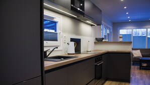 A modern kitchen with dark cabinetry, a built-in oven, and a microwave. - Vacation cottage Noa (Twist)