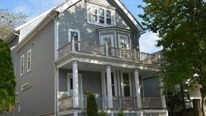 A two-story house with a balcony, a front porch, and a garage.