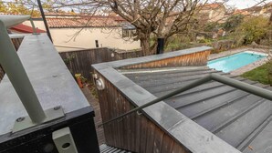 A rooftop with a pool, wooden deck, and a metal railing. - Oyasumi - MURET - Gîte (MURET)