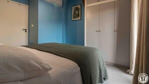 A bedroom with a bed, a wardrobe, and a painting on the wall. - Oyasumi - MURET - Gîte (MURET)