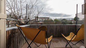 A balcony with two yellow chairs and a wooden fence. - Oyasumi - MURET - Gîte (MURET)