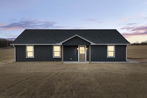 A modern two-story house with a dark exterior, a front door, and three windows. - Royal Flush Villa - King Bed near WinStar (Thackerville)