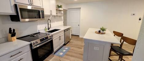 Een microgolfoven, een oven, een kookplaat, een vaatwasser