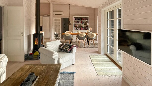 A cozy living room with a fireplace, a sofa, a coffee table, and a bookshelf. - Stunning home in Højby with WiFi (Højby)
