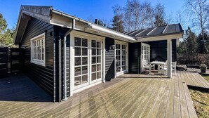 A house with a deck, a fireplace, and a covered outdoor seating area. - Stunning home in Højby with WiFi (Højby)