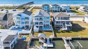 Un quartier résidentiel situé sur la côte, composé de plusieurs maisons à deux étages, d’une jetée et d’un port de plaisance.
