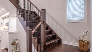 Un escalier en bois, doté d’une rampe, menant à l’étage supérieur.