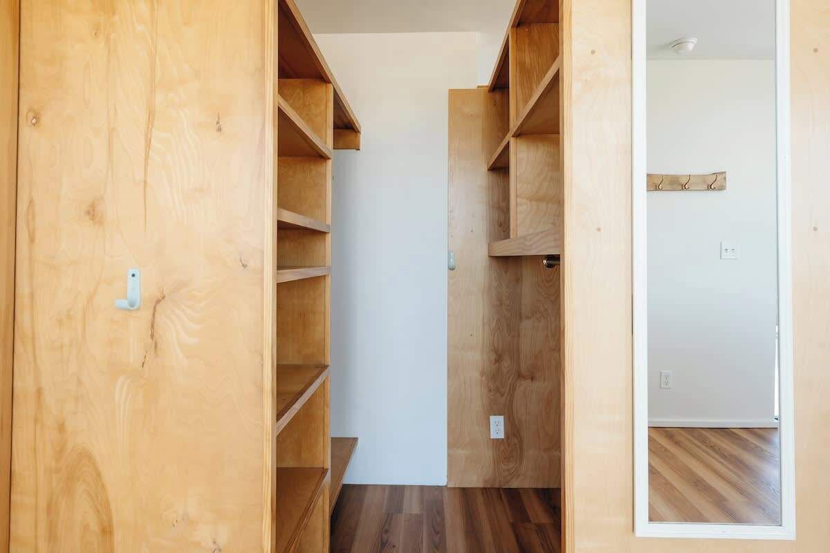 Un interior de madera con estantes empotrados y una pared blanca.