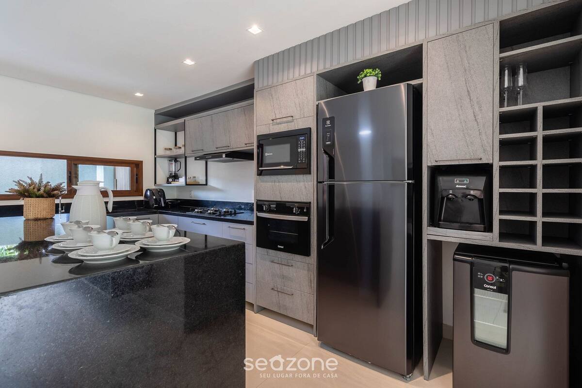 A modern kitchen with built-in appliances, a central island, and a water dispenser.