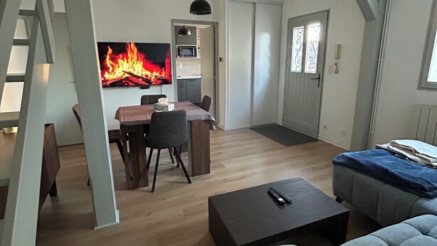 Ein modernes Wohnzimmer mit Kamin, Essbereich und einer Treppe.