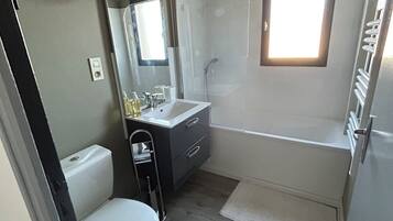 Een haardroger, handdoeken, zeep, toiletpapier