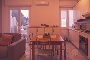 A compact kitchen with a dining table, chairs, a sofa, and a small refrigerator. - Città di Brescia adorable 4 person apartment with AC in Brescia Hospital Area (Brescia)